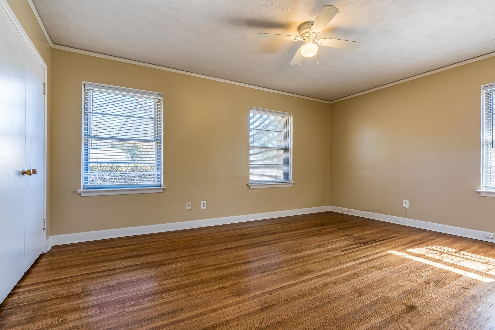 1117 South Perkins Road Memphis, TN 38117 - Photo 16 of 24 a view of an empty room with window and wooden floor