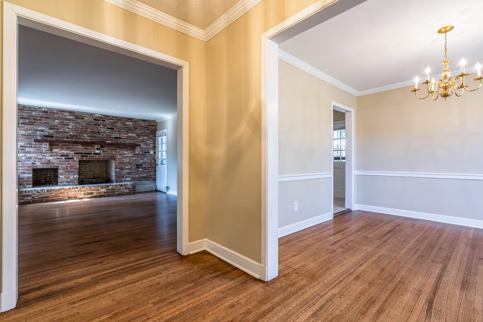 1117 South Perkins Road Memphis, TN 38117 - Photo 5 of 24 an empty room with wooden floor fireplace and staircase