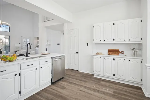 a kitchen with white cabinets and sink