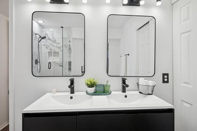 a bathroom with double vanity sinks and a mirror
