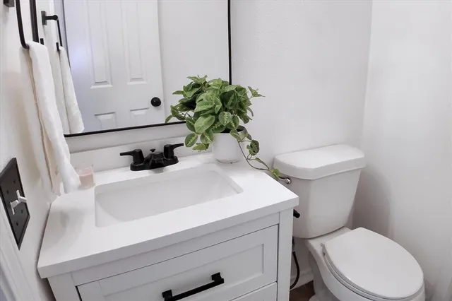 a bathroom with a sink a toilet and a mirror