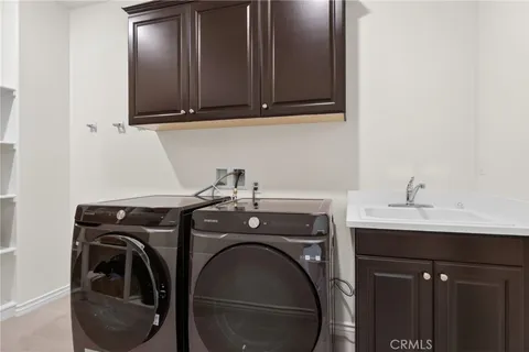 a utility room with sink dryer and washer