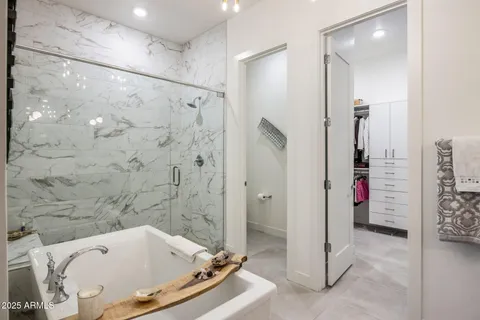 a spacious bathroom with a tub sink and mirror