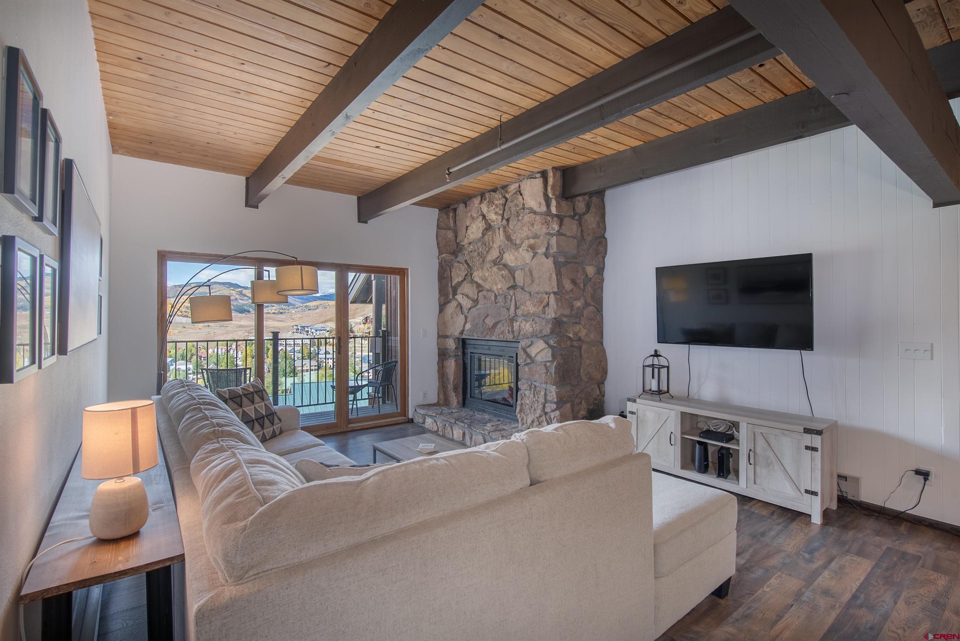 32 Hunter Hill Road, Unit B102 Crested Butte, CO 81225 - Photo 13 of 28 a living room with furniture a flat screen tv and a fireplace