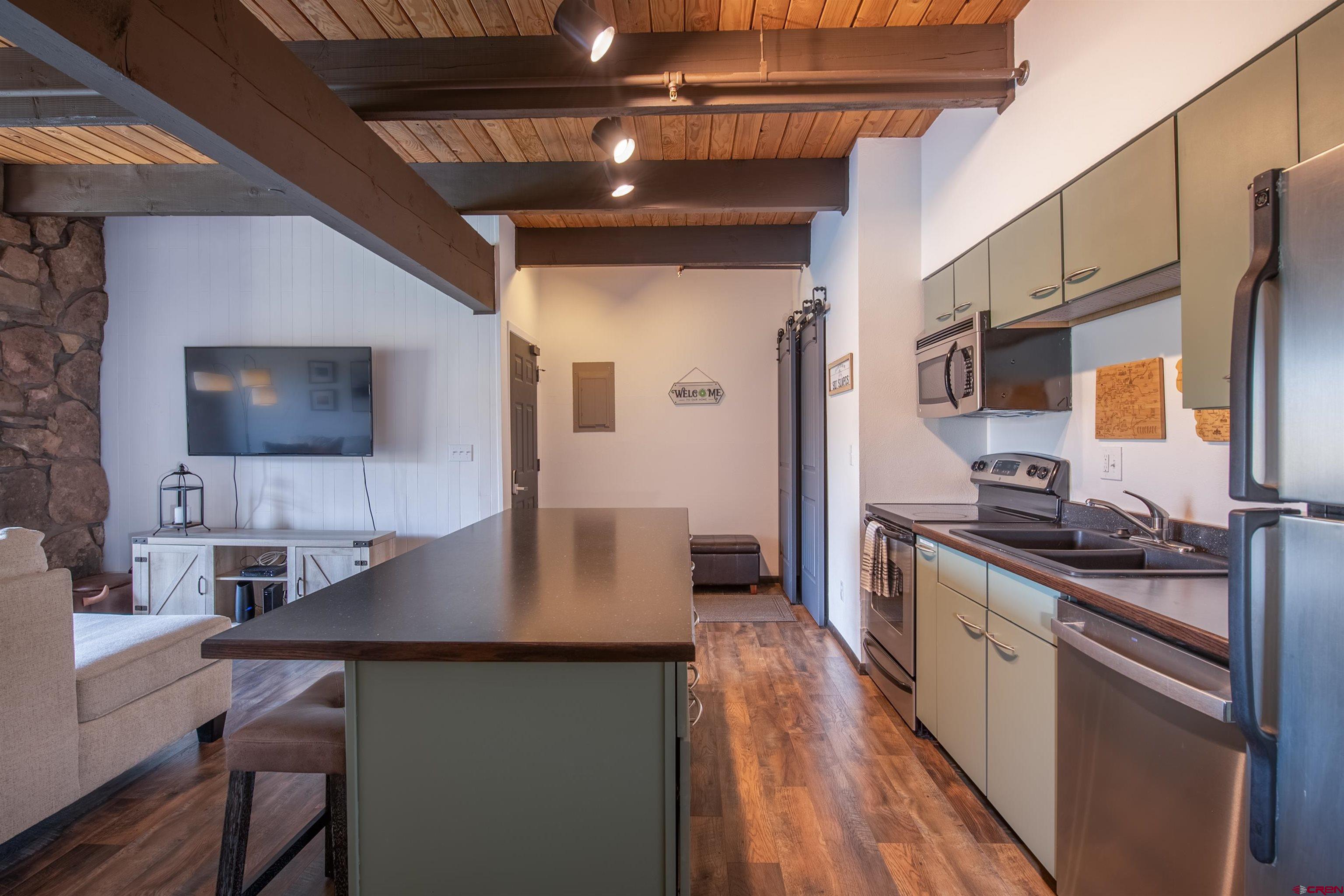 32 Hunter Hill Road, Unit B102 Crested Butte, CO 81225 - Photo 14 of 28 a kitchen with stainless steel appliances granite countertop a sink stove and refrigerator