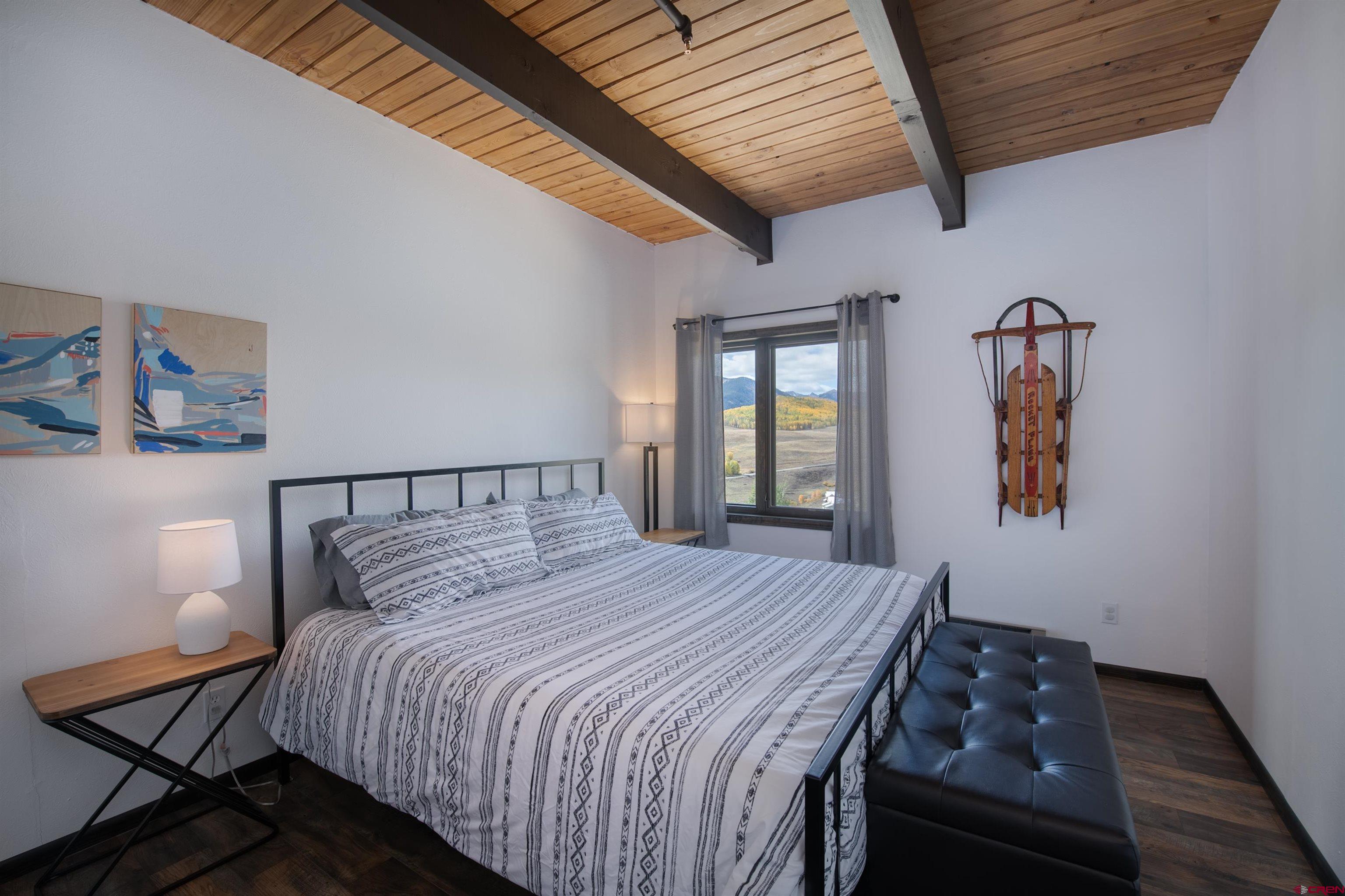 32 Hunter Hill Road, Unit B102 Crested Butte, CO 81225 - Photo 15 of 28 a bedroom with a bed and wooden floor