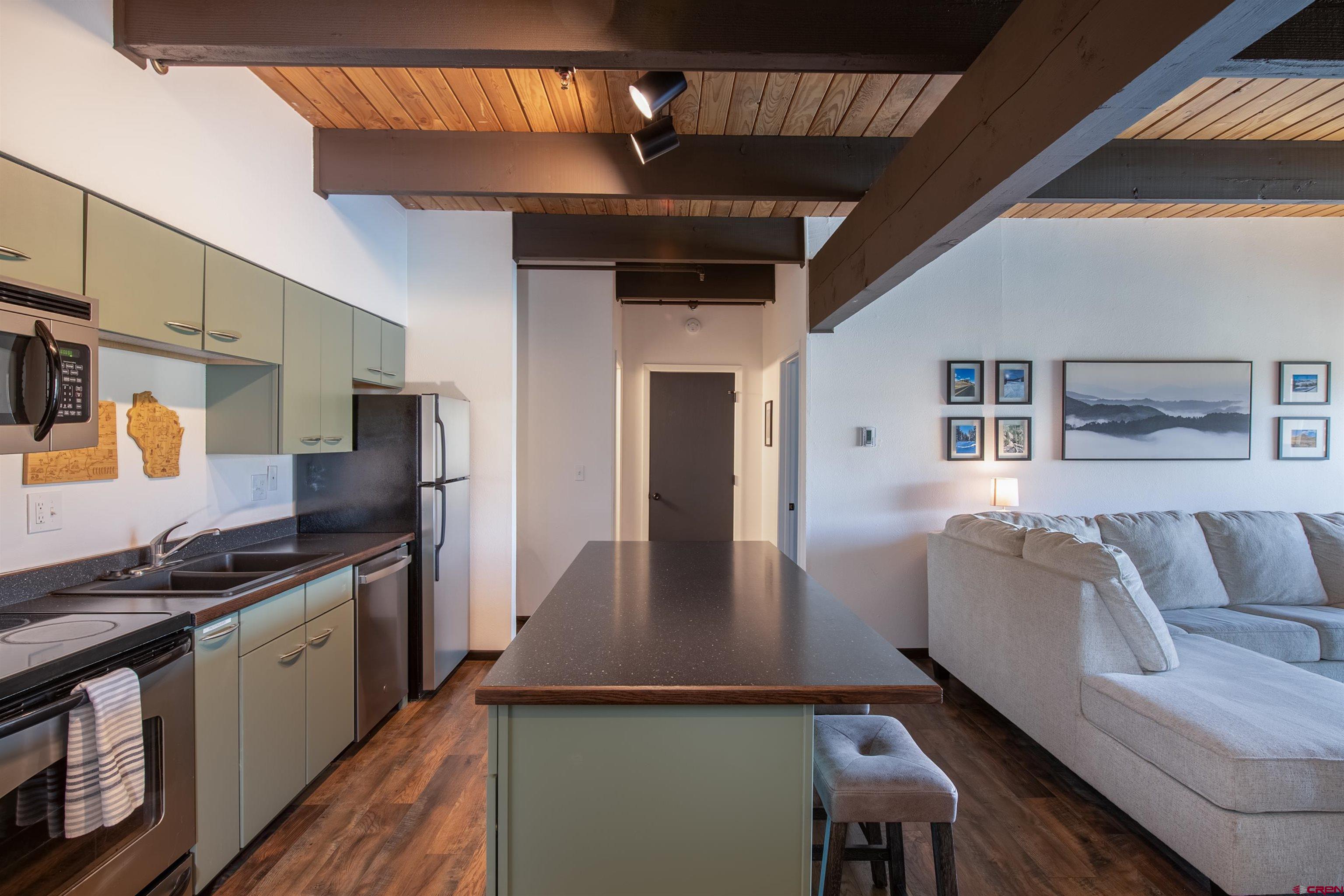 32 Hunter Hill Road, Unit B102 Crested Butte, CO 81225 - Photo 3 of 28 a kitchen with stainless steel appliances granite countertop a refrigerator a stove and a sink with dishwasher