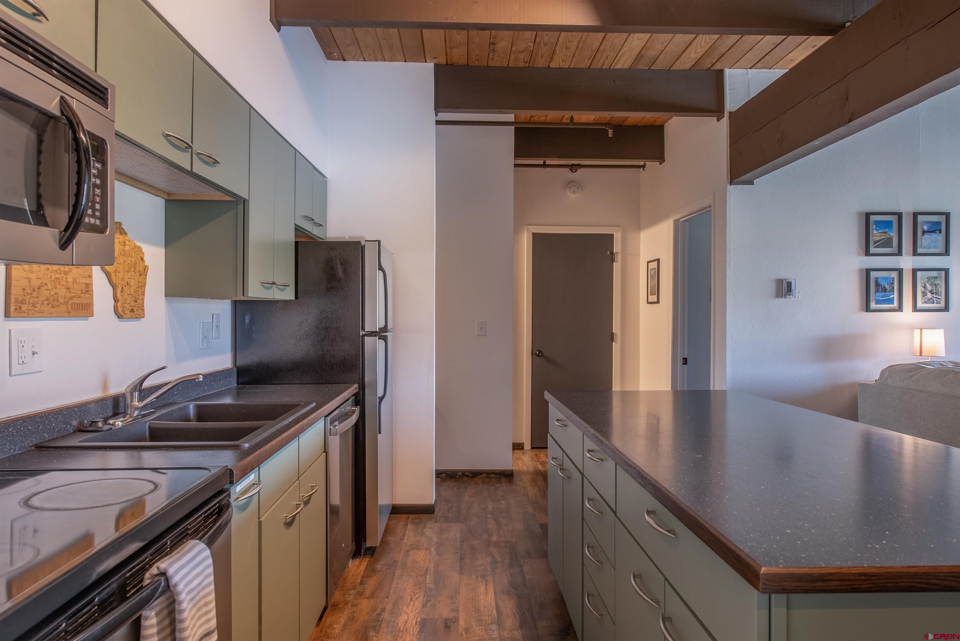 32 Hunter Hill Road, Unit B102 Crested Butte, CO 81225 - Photo 4 of 28 a kitchen with stainless steel appliances granite countertop a sink stove and refrigerator