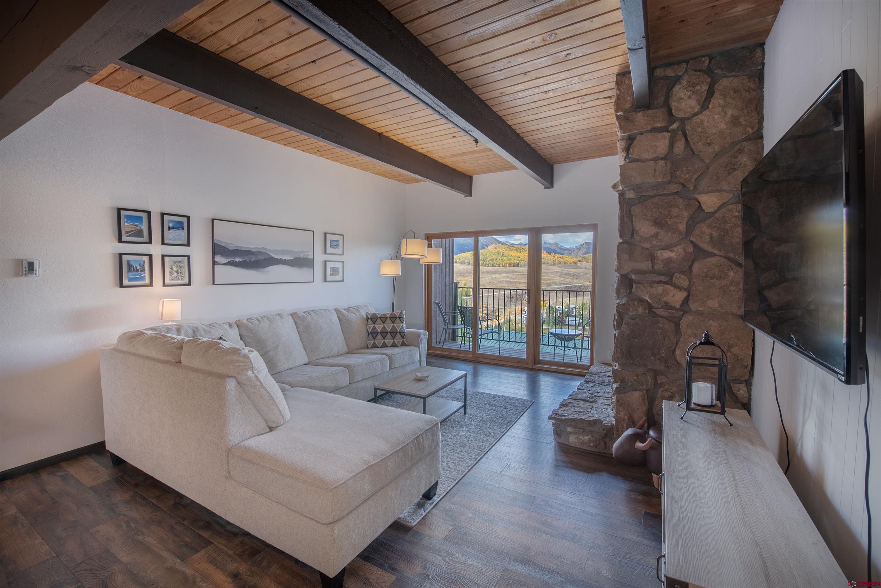 32 Hunter Hill Road, Unit B102 Crested Butte, CO 81225 - Photo 5 of 28 a living room with furniture wooden floor and a flat screen tv
