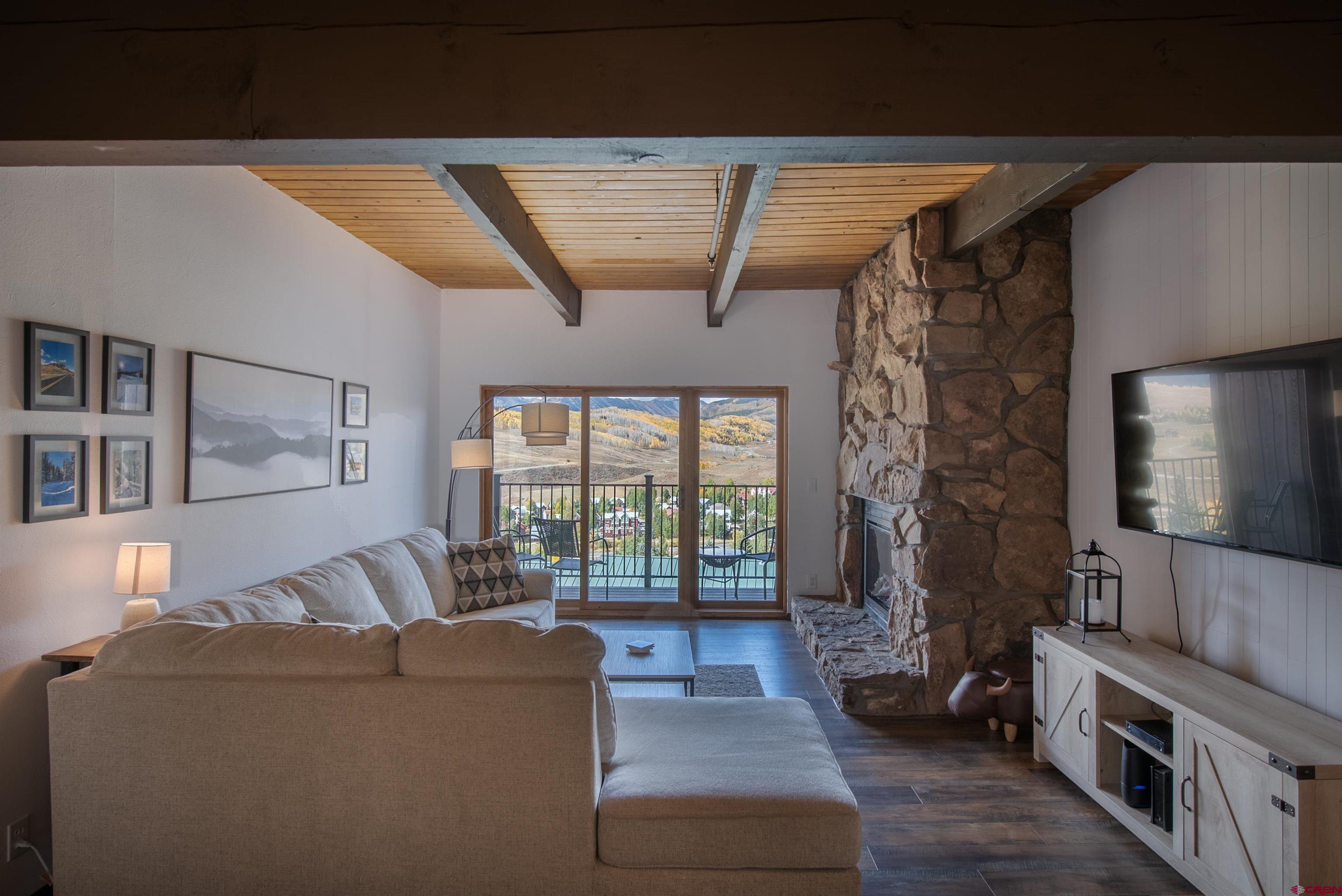32 Hunter Hill Road, Unit B102 Crested Butte, CO 81225 - Photo 6 of 28 a living room with furniture and a flat screen tv