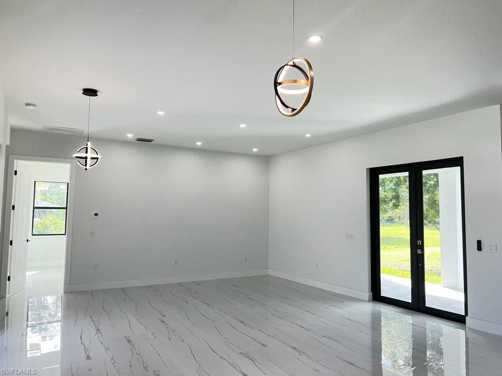 3302 East 3rd Street Lehigh Acres, FL 33936 - Photo 11 of 23 an empty room with wooden floor and windows