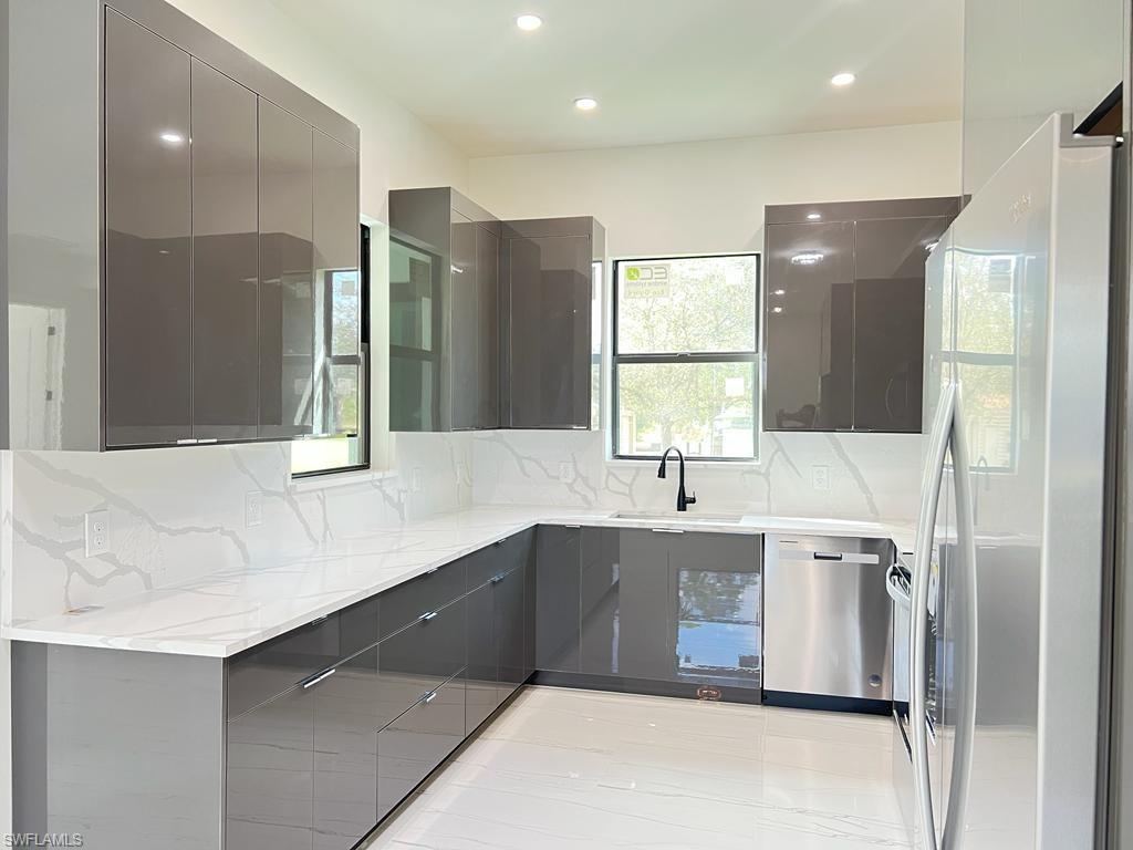 3302 East 3rd Street Lehigh Acres, FL 33936 - Photo 13 of 23 a kitchen with a sink stove and refrigerator