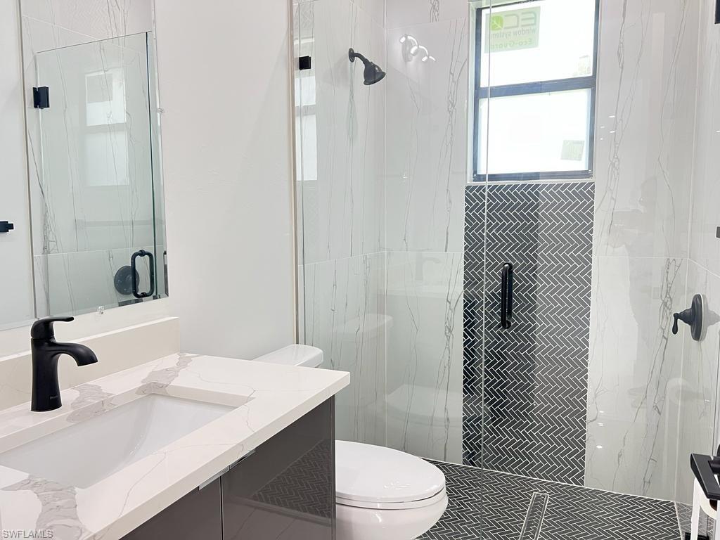 3302 East 3rd Street Lehigh Acres, FL 33936 - Photo 15 of 23 a bathroom with a sink a toilet and shower