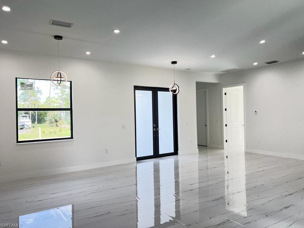 3302 East 3rd Street Lehigh Acres, FL 33936 - Photo 17 of 23 an empty room with wooden floor and windows