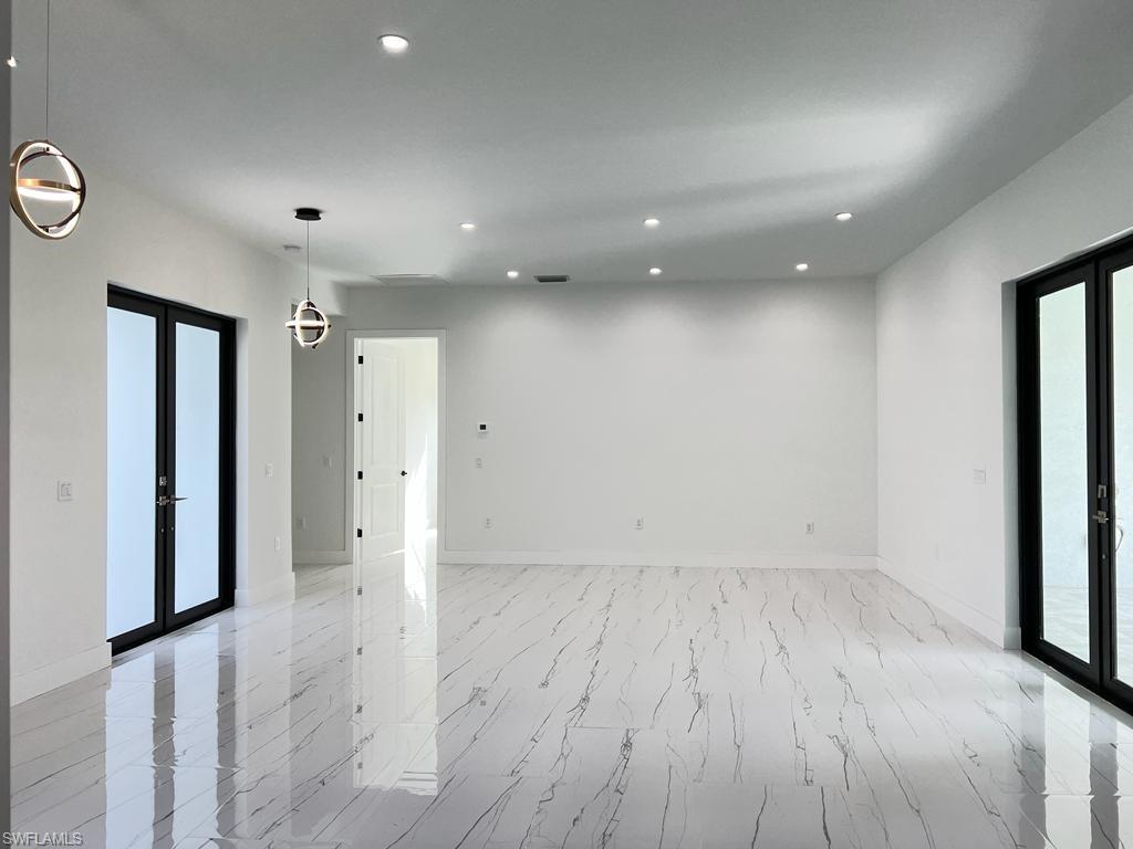3302 East 3rd Street Lehigh Acres, FL 33936 - Photo 18 of 23 an empty room with wooden floor and entrance