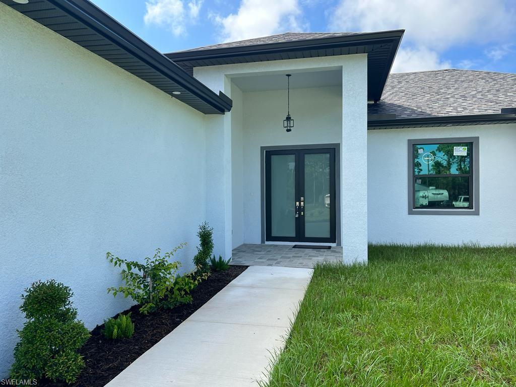 3302 East 3rd Street Lehigh Acres, FL 33936 - Photo 2 of 23 a front view of a house with a yard