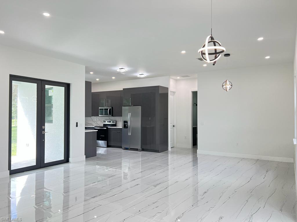 3302 East 3rd Street Lehigh Acres, FL 33936 - Photo 5 of 23 a view of a room with a chandelier and living room