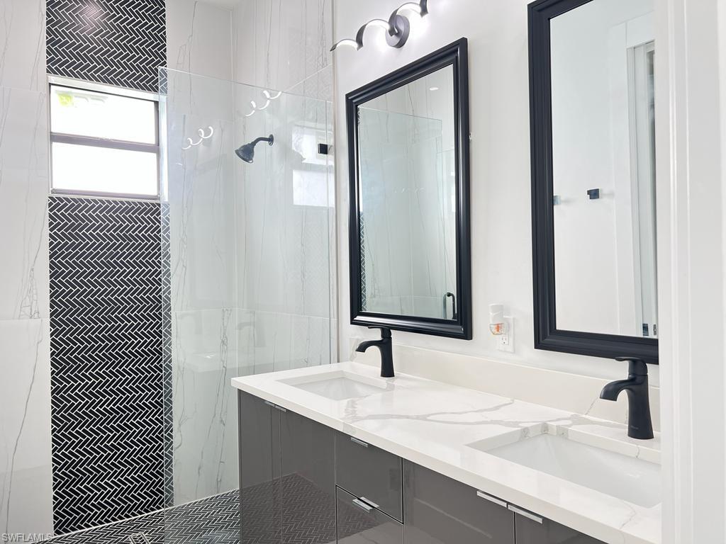 3302 East 3rd Street Lehigh Acres, FL 33936 - Photo 7 of 23 a bathroom with a granite countertop sink and a mirror