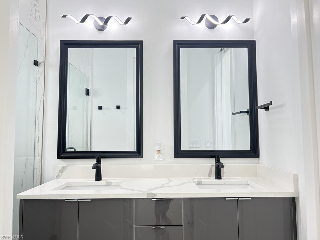 3302 East 3rd Street Lehigh Acres, FL 33936 - Photo 8 of 23 a bathroom with double sink and a mirror