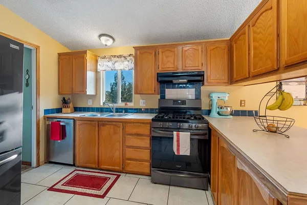 a kitchen with stainless steel appliances granite countertop a refrigerator and a sink