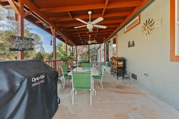 a view of a patio with a table and chairs and potted plants