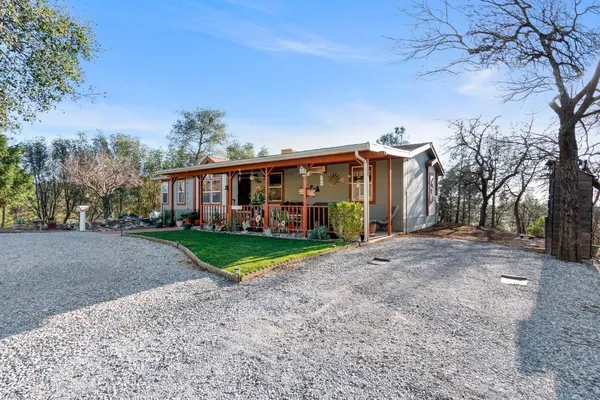 a view of swimming pool with outdoor seating and trees in the background