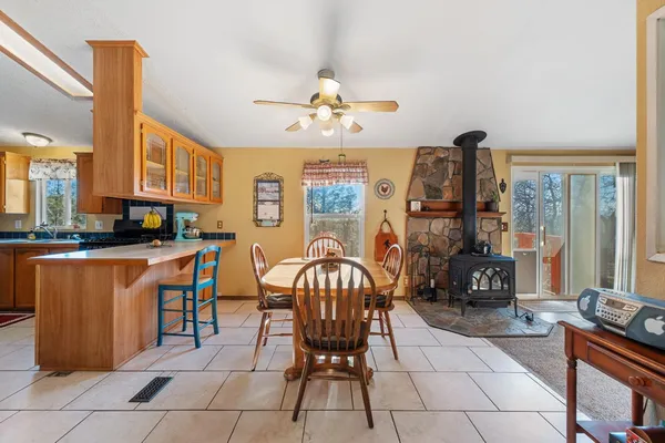 a kitchen with stainless steel appliances granite countertop a stove a refrigerator a kitchen island a stove a sink dishwasher a dining table and chairs with wooden floor