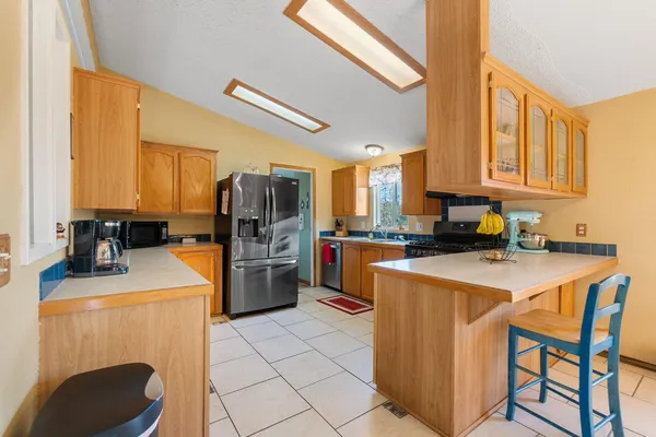 a kitchen with stainless steel appliances granite countertop a stove a sink and a refrigerator