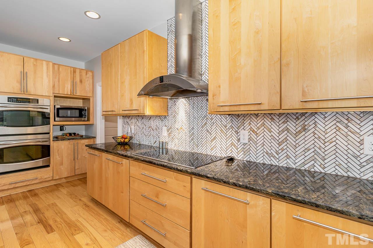 412 Deep Woods Trail Wake Forest, NC 27587 - Photo 30 of 35 a kitchen with stainless steel appliances a sink a stove and white cabinets