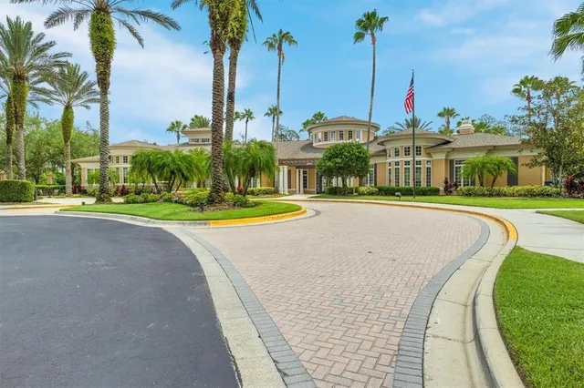 a view of a swimming pool with a yard and palm trees