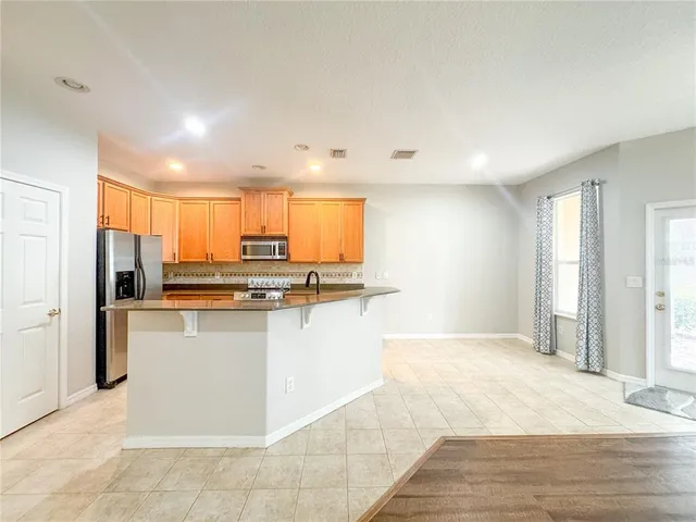 a kitchen with stainless steel appliances granite countertop a refrigerator and a sink