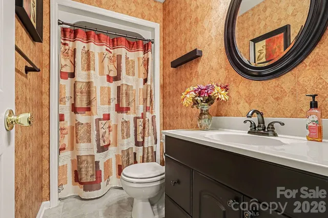 a bathroom with a sink a toilet and a mirror