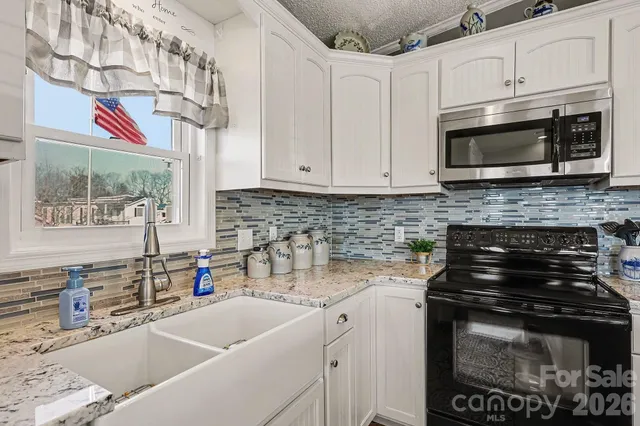 a kitchen with stainless steel appliances granite countertop a sink stove and microwave