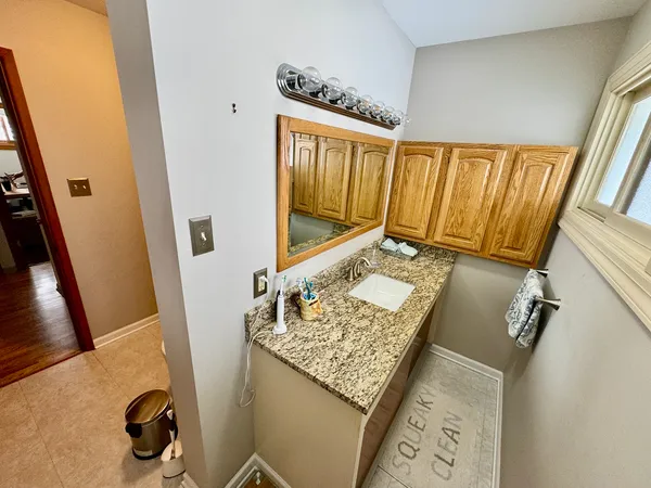 a bathroom with a granite countertop sink and a mirror