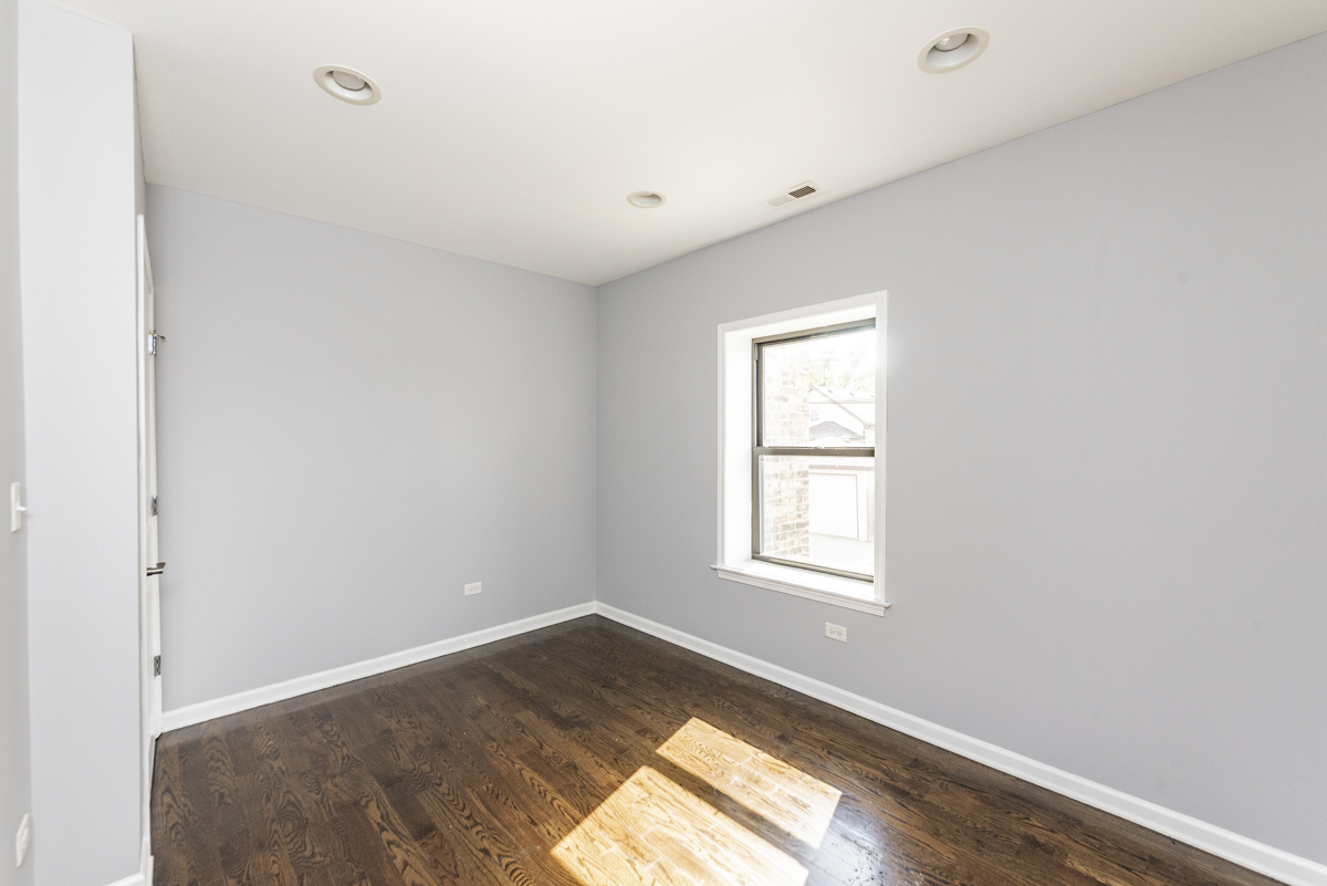 1012 South 1st Avenue, Unit 103 Maywood, IL 60153 - Photo 11 of 13 a view of empty room with wooden floor and fan