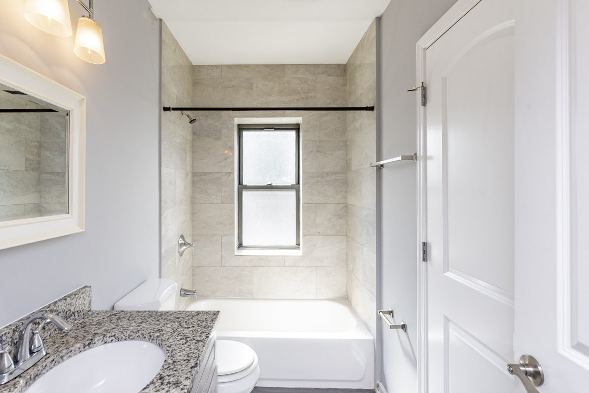 1012 South 1st Avenue, Unit 103 Maywood, IL 60153 - Photo 12 of 13 a bathroom with a granite countertop sink toilet and shower