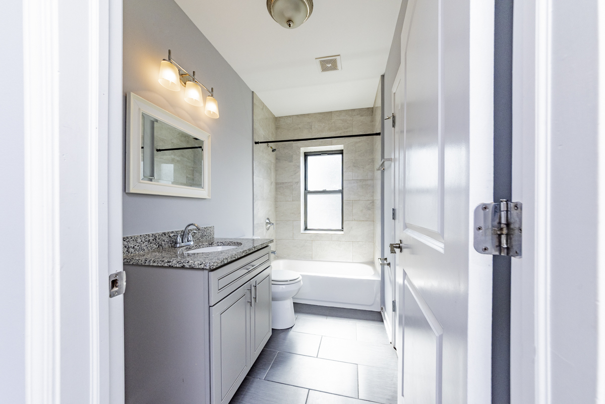 1012 South 1st Avenue, Unit 103 Maywood, IL 60153 - Photo 13 of 13 a bathroom with a granite countertop sink mirror and a bathtub