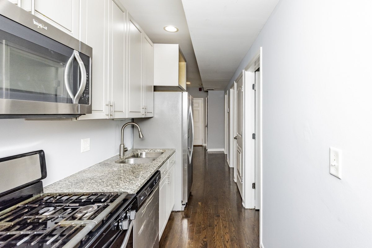 1012 South 1st Avenue, Unit 103 Maywood, IL 60153 - Photo 2 of 13 a kitchen with granite countertop a sink stove and cabinets