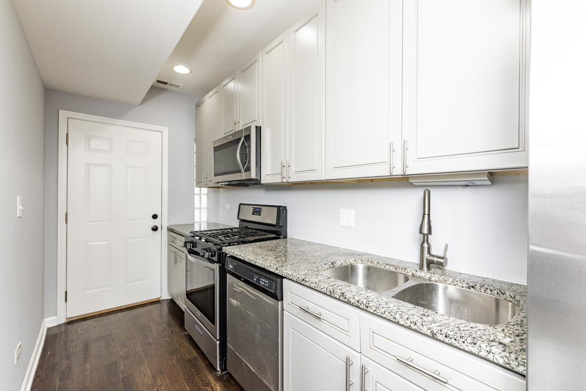1012 South 1st Avenue, Unit 103 Maywood, IL 60153 - Photo 6 of 13 a kitchen with granite countertop a sink stainless steel appliances and cabinets