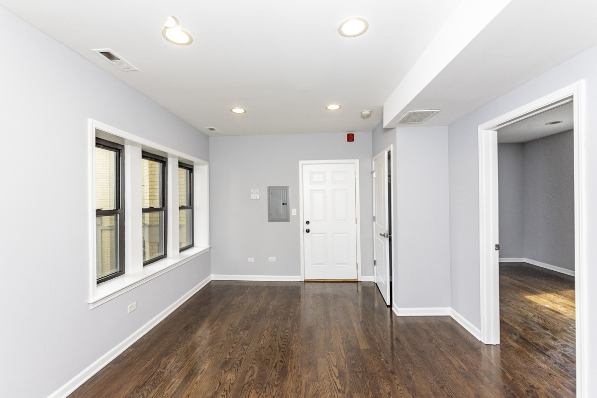1012 South 1st Avenue, Unit 103 Maywood, IL 60153 - Photo 7 of 13 a view of a big room with wooden floor and windows