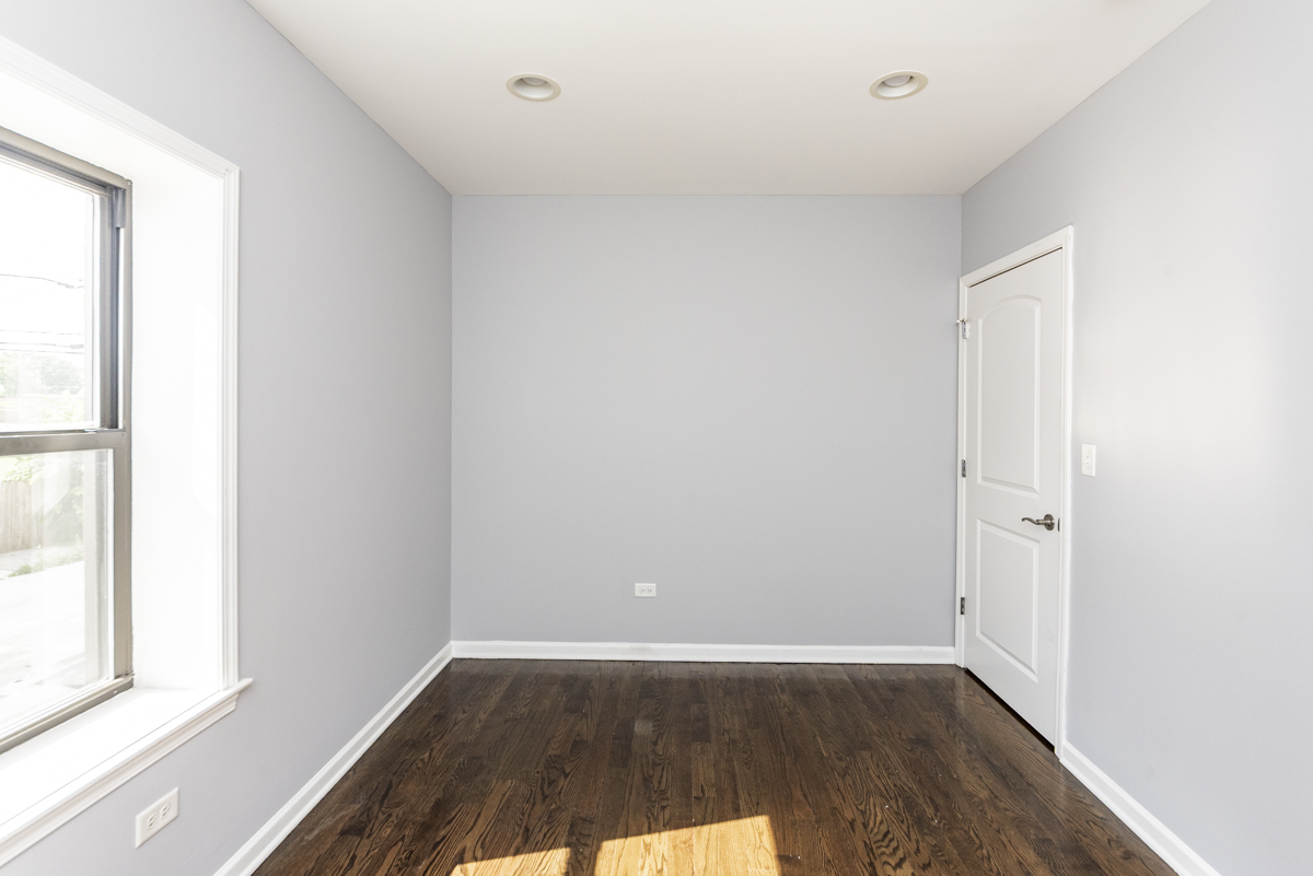 1012 South 1st Avenue, Unit 103 Maywood, IL 60153 - Photo 10 of 13 an empty room with wooden floor and windows