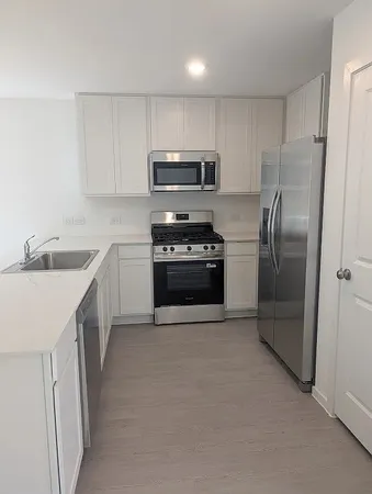 a kitchen with stainless steel appliances granite countertop a refrigerator sink and stove