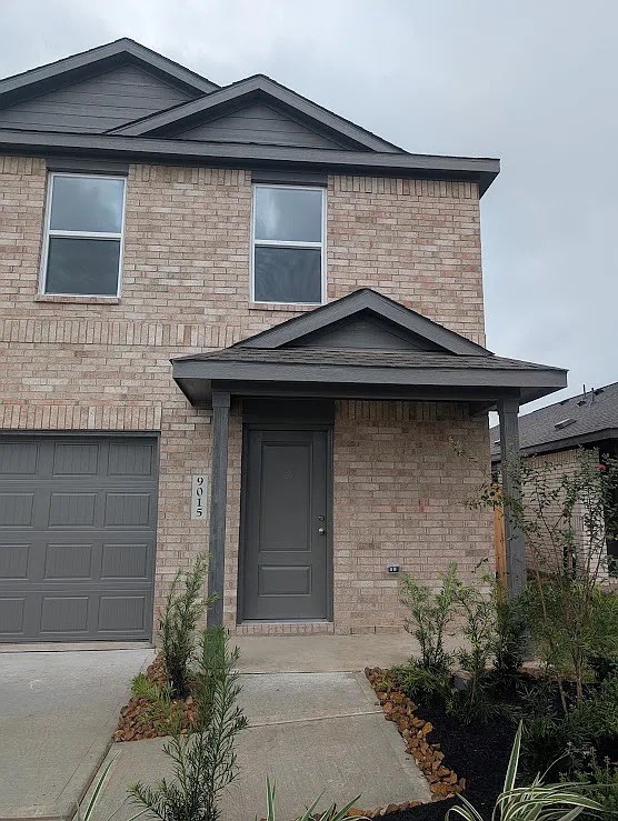 9015 Rose Pelican Lane Baytown, TX 77521 - Photo 2 of 14 a front view of a house with garden