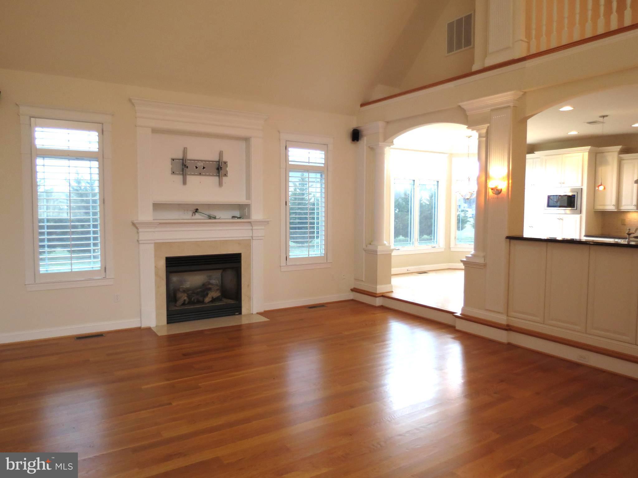 6170 Scaggs Road Owings, MD 20736 - Photo 13 of 30 an empty room with wooden floor a fireplace and windows