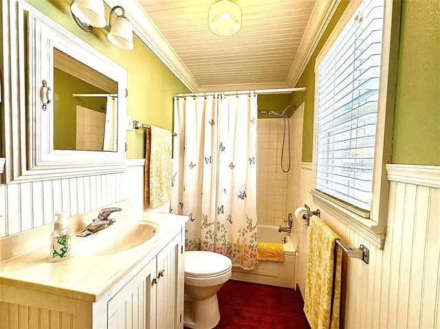 a bathroom with a sink a toilet a mirror and a shower