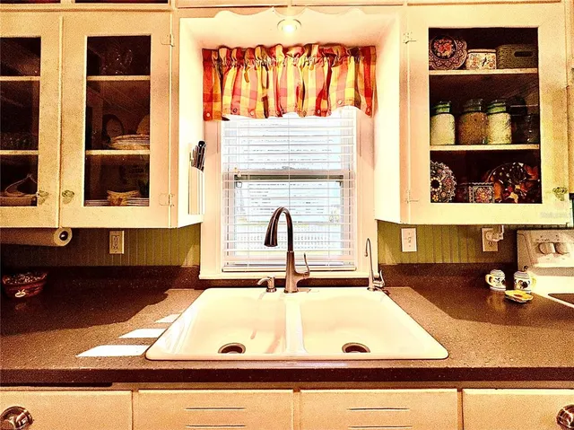 a bathroom with a granite countertop sink and a window