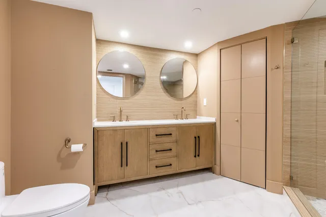 a bathroom with a double vanity sink mirror and toilet