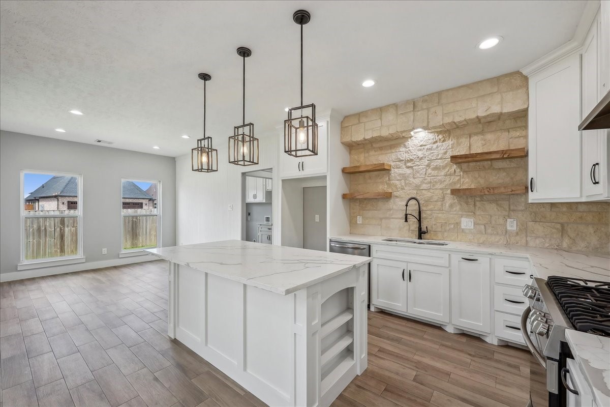 7722 Pond Circle Beaumont, TX 77707 - Photo 11 of 34 a kitchen with stainless steel appliances granite countertop a sink a stove a refrigerator and island with wooden floor