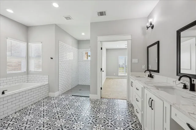 a spacious bathroom with a double vanity sink a mirror and a shower