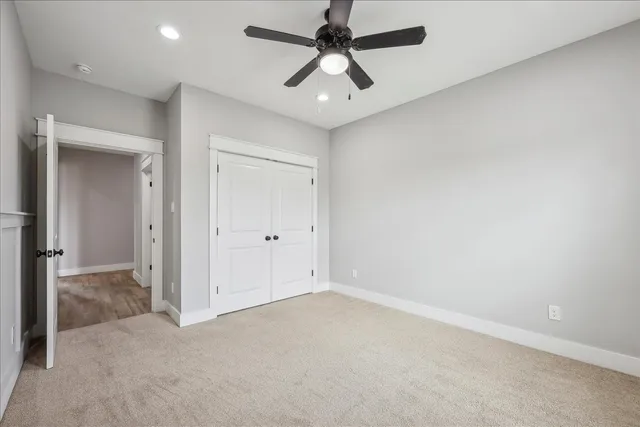 an empty room with chandelier fan